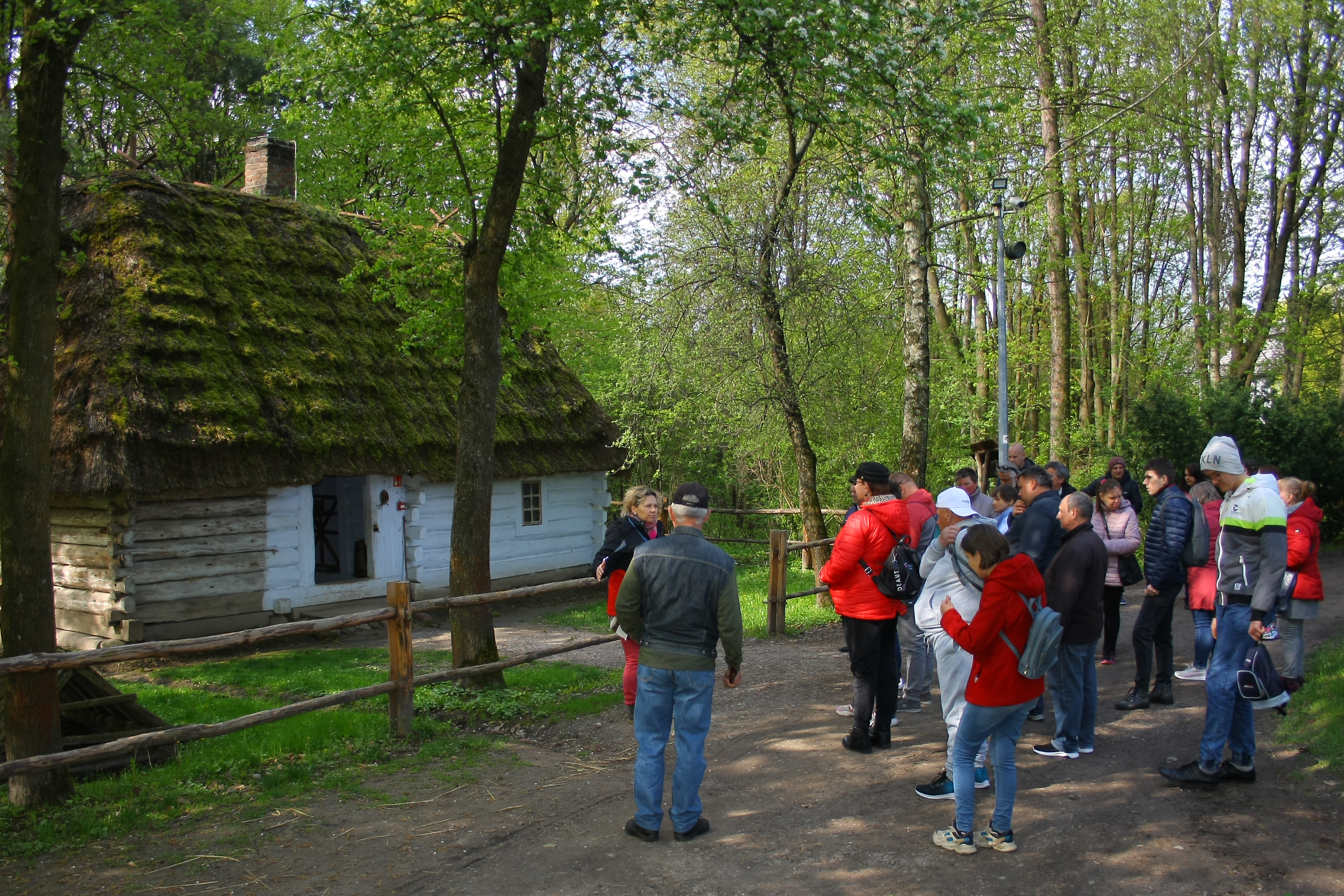 Grupa osób zwiedzająca skansen