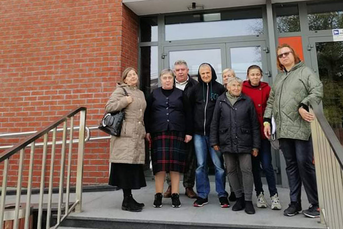 Grupka osób stojąca przed budynkiem