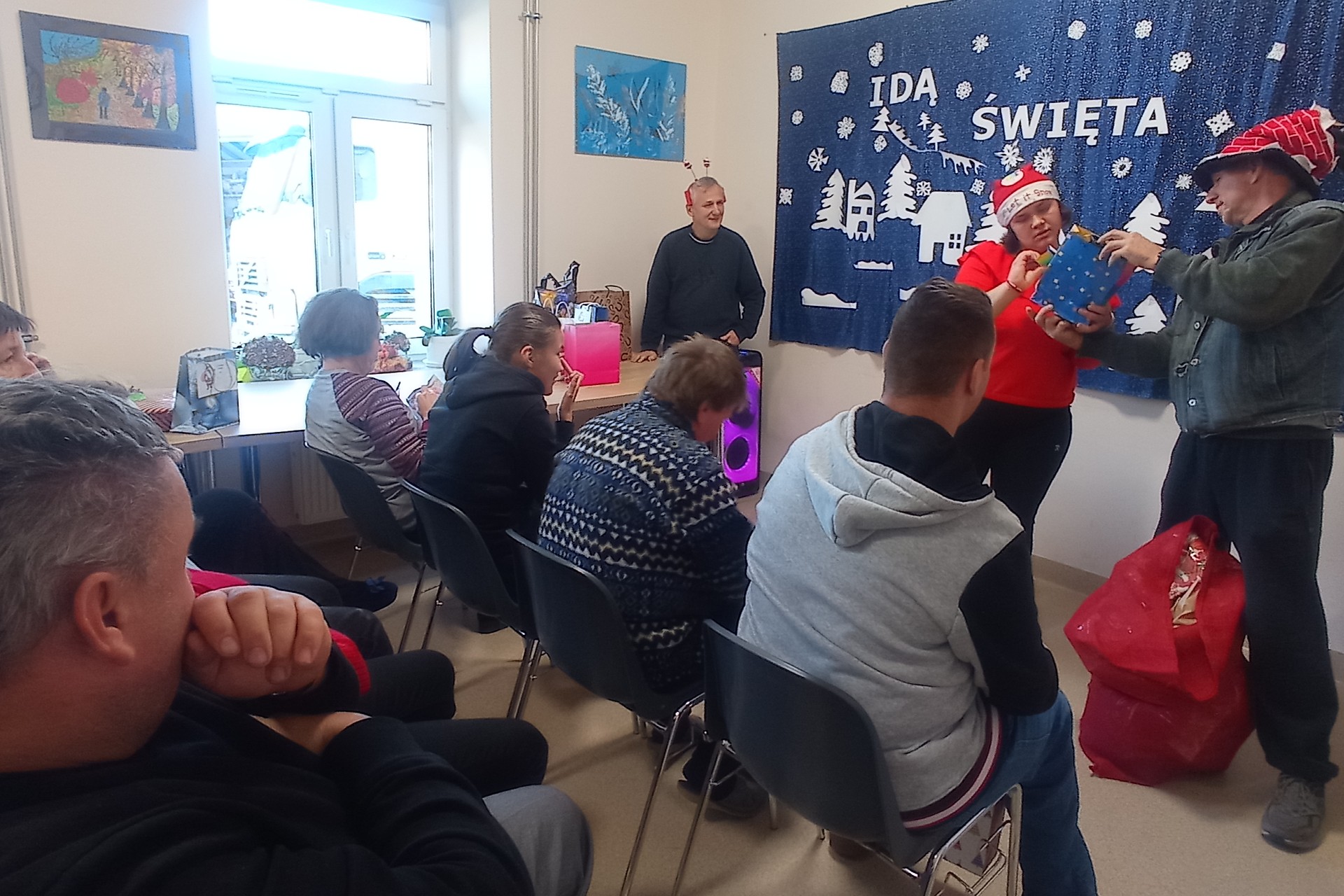 Grupa osób obdarowująca się prezentami